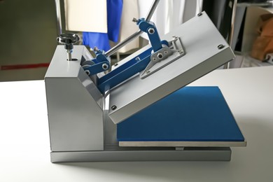 Photo of Printing logo. Modern heat press machine on white table