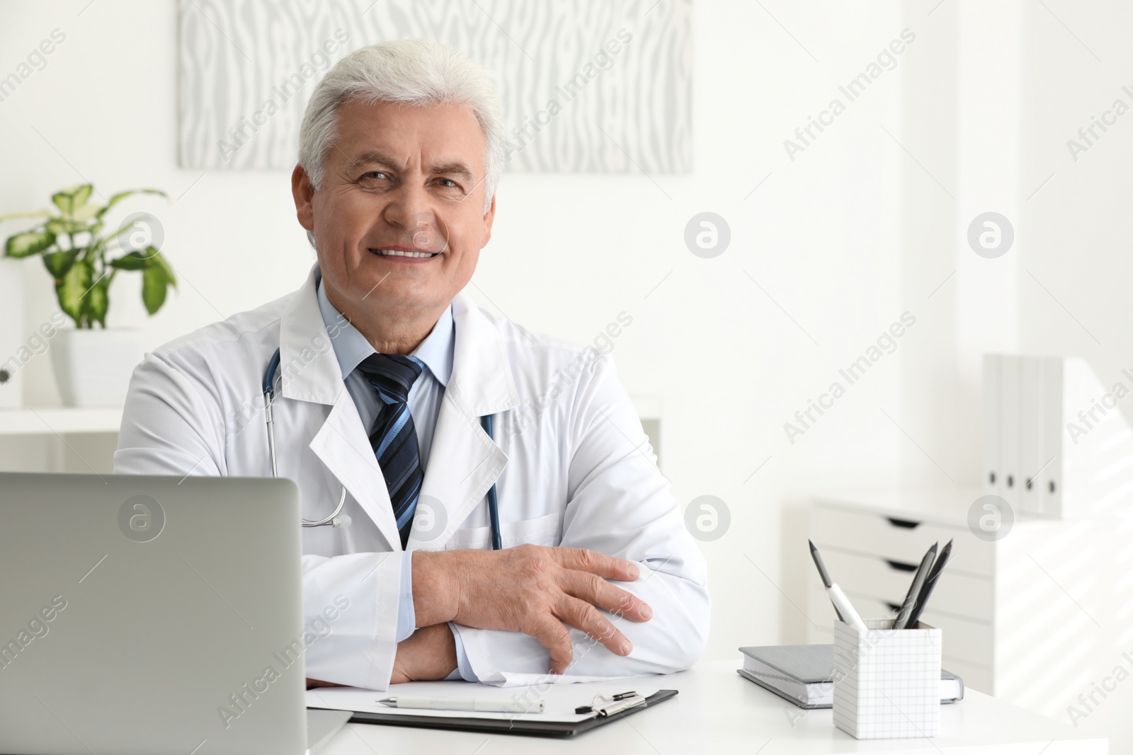 Photo of Portrait of senior doctor in white coat at workplace