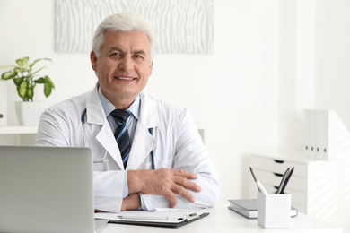 Photo of Portrait of senior doctor in white coat at workplace