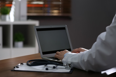 Professional doctor working on laptop in office, closeup