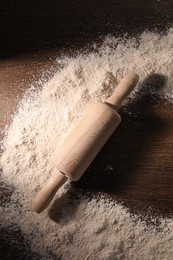 Frame of flour and rolling pin on wooden table, top view. Space for text