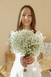 Photo of Happy bride with beautiful bouquet indoors, focus on flowers. Wedding day