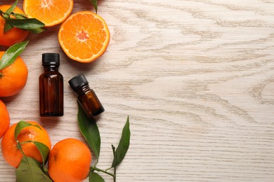 Photo of Flat lay composition with tangerine essential oil on wooden table. Space for text