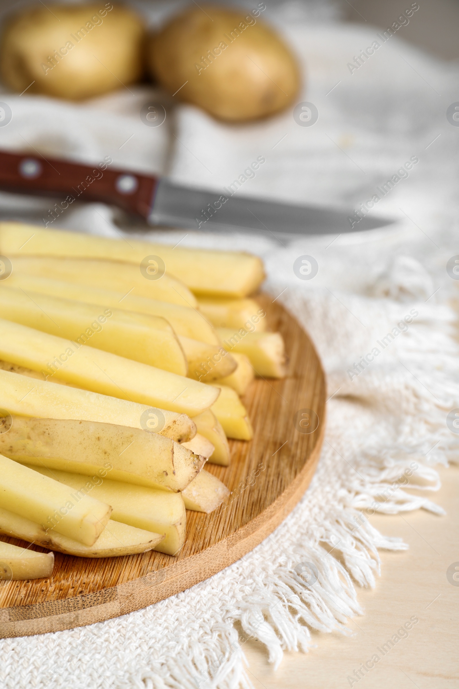 Photo of Cut raw potatoes on white table, closeup