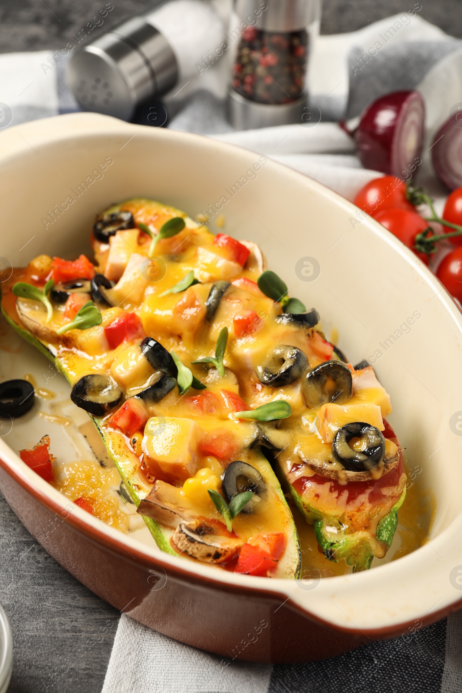 Photo of Baking dish with delicious stuffed zucchinis on table, closeup