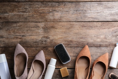 Photo of Stylish footwear with shoe care accessories on wooden table, flat lay. Space for text