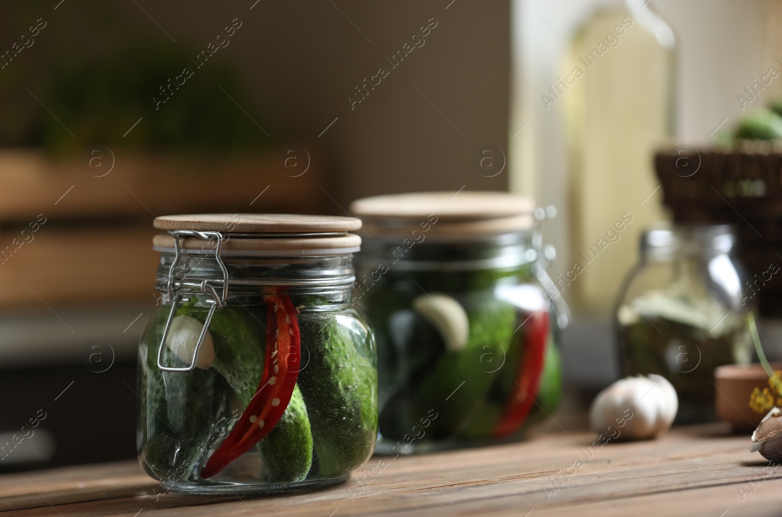 Photo of Jar of pickled cucumbers on wooden table. Space for text