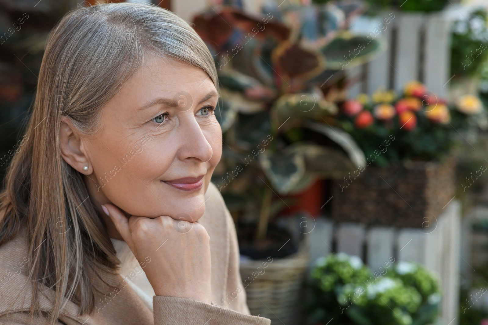 Photo of Beautiful senior woman sitting outdoors, space for text