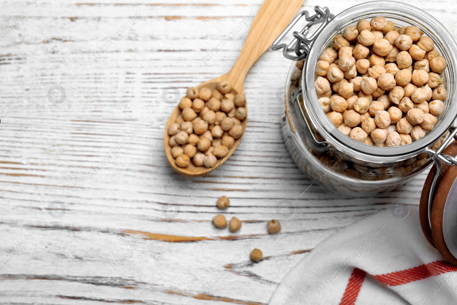 Photo of Raw chickpeas on white wooden table, flat lay. Space for text