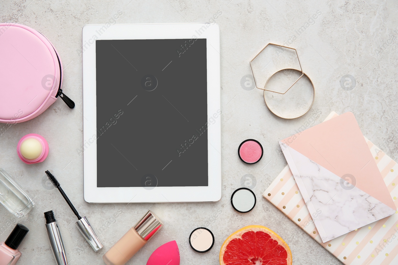 Photo of Flat lay composition with tablet and makeup products on grey background