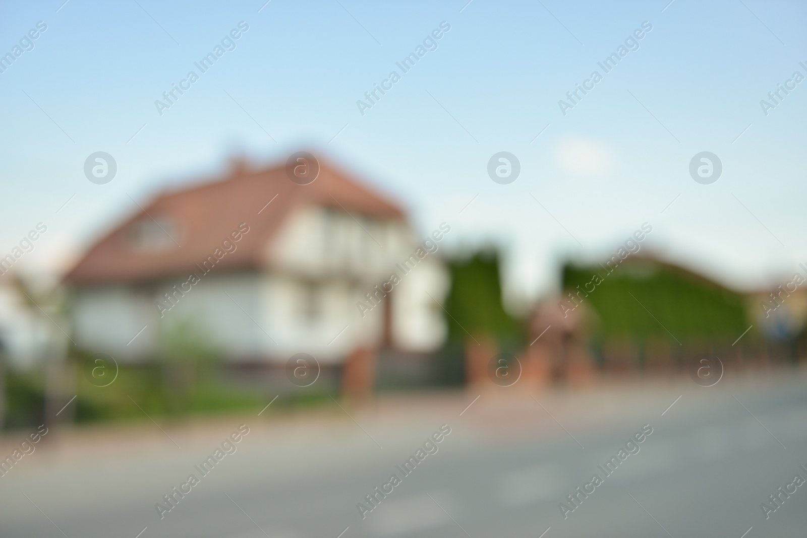 Photo of Blurred view of suburban street with beautiful house