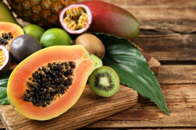 Fresh ripe papaya and other fruits on wooden table. Space for text