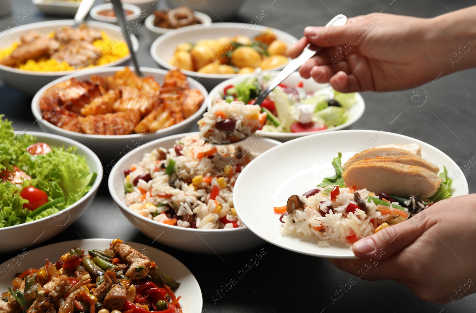 Photo of Woman taking food from buffet table, closeup