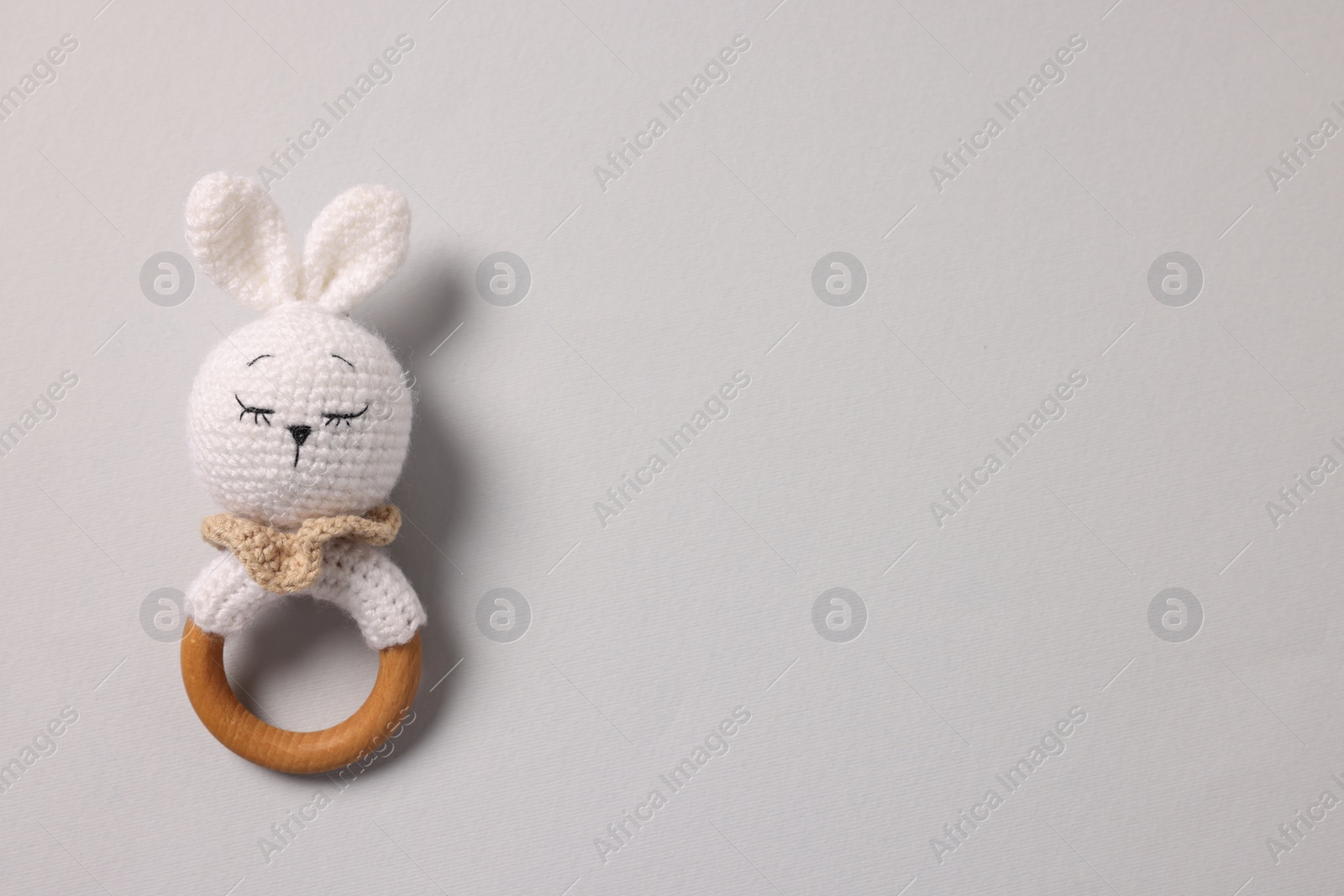 Photo of Baby accessory. Rattle on grey background, top view. Space for text