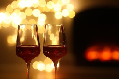 Photo of Glasses of wine against blurred lights, closeup with space for text. Romantic dinner