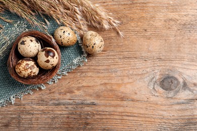 Photo of Flat lay composition with quail eggs on wooden table. Space for text