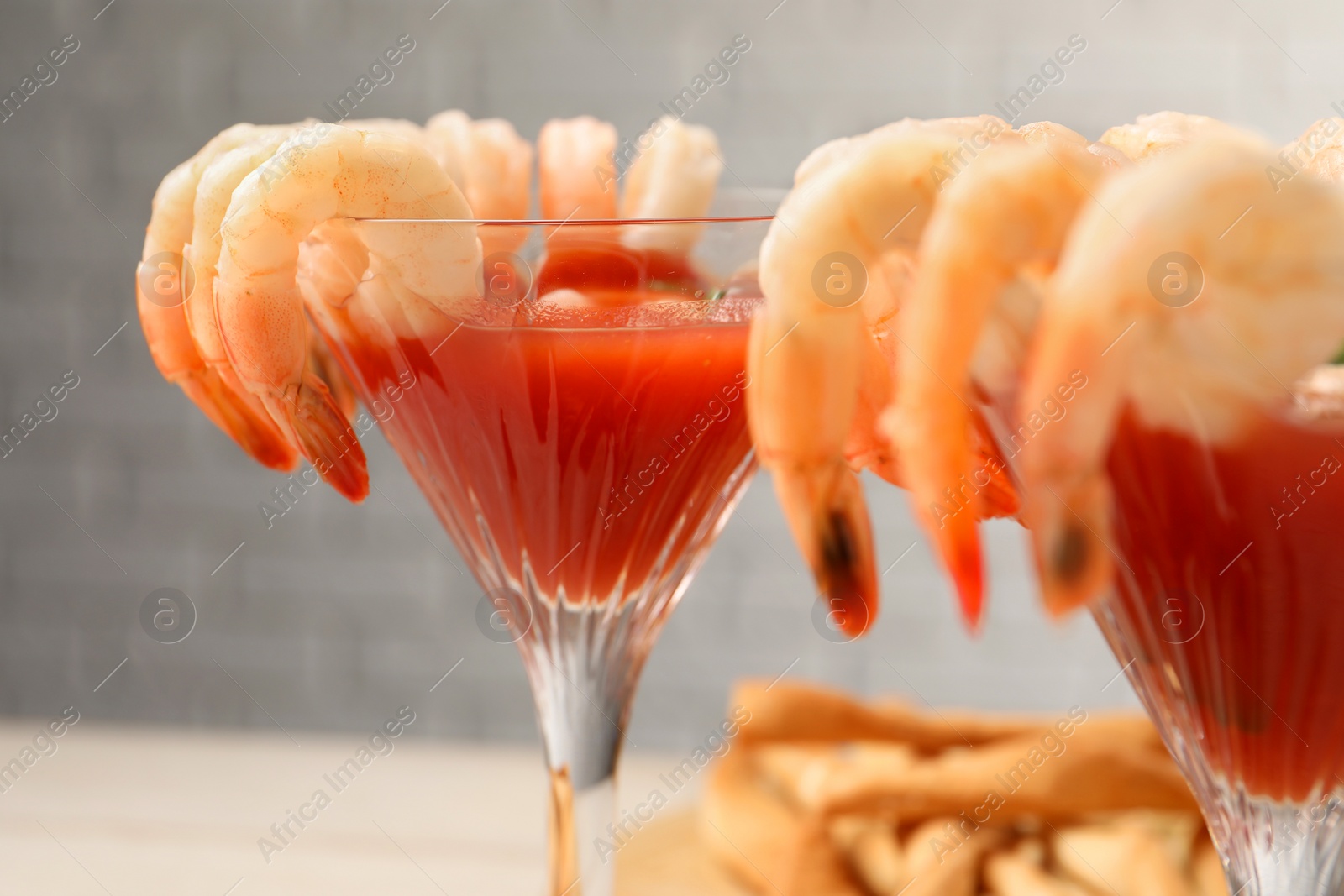 Photo of Tasty shrimp cocktail with sauce in glasses on table, closeup