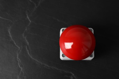 Photo of Red button of nuclear weapon on black background, top view with space for text. War concept