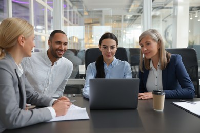 Photo of Lawyers working together with laptop at table in office