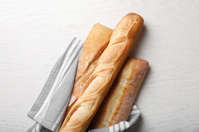 Photo of Different tasty baguettes on white wooden table, flat lay