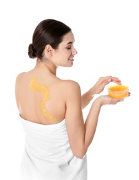 Young woman applying body scrub on white background