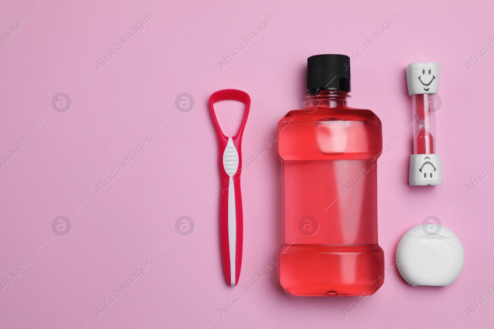 Photo of Tongue cleaner, dental floss, mouthwash and hourglass on pink background, flat lay. Space for text