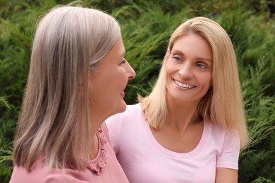 Happy mature mother and her daughter outdoors