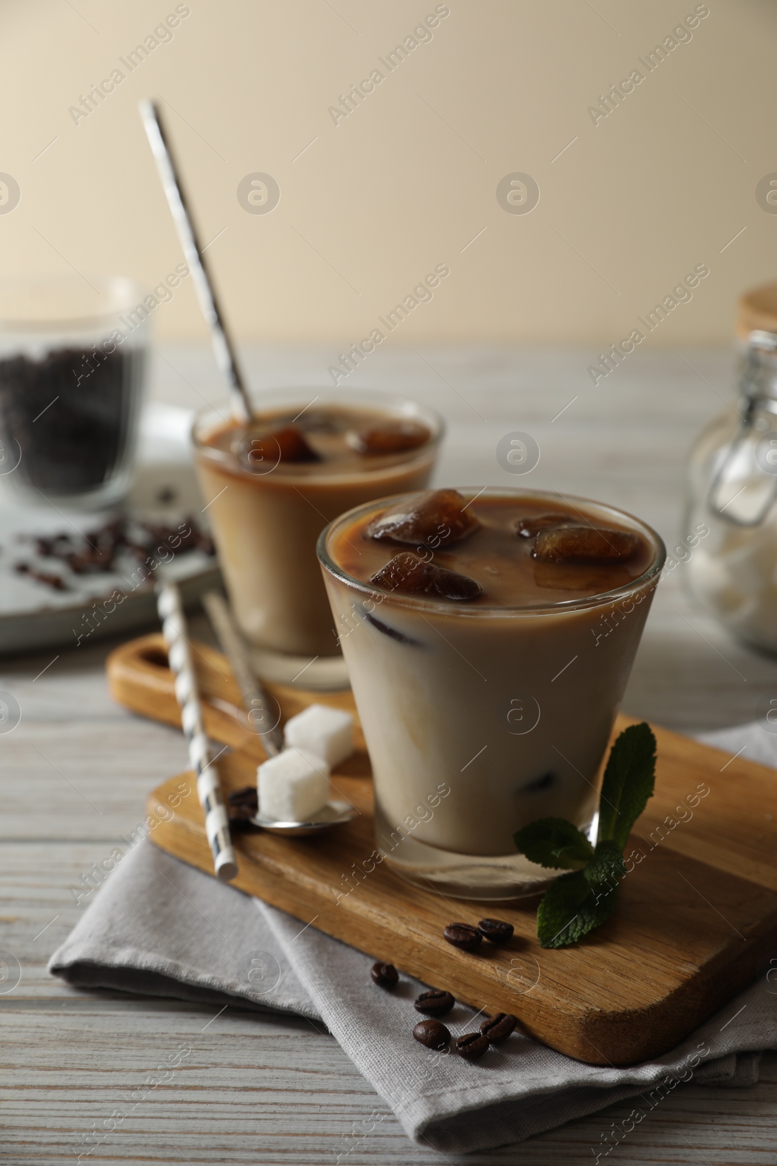 Photo of Delicious iced coffee on white wooden table, closeup. Space for text