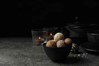 Delicious vegan candy balls on grey table, space for text