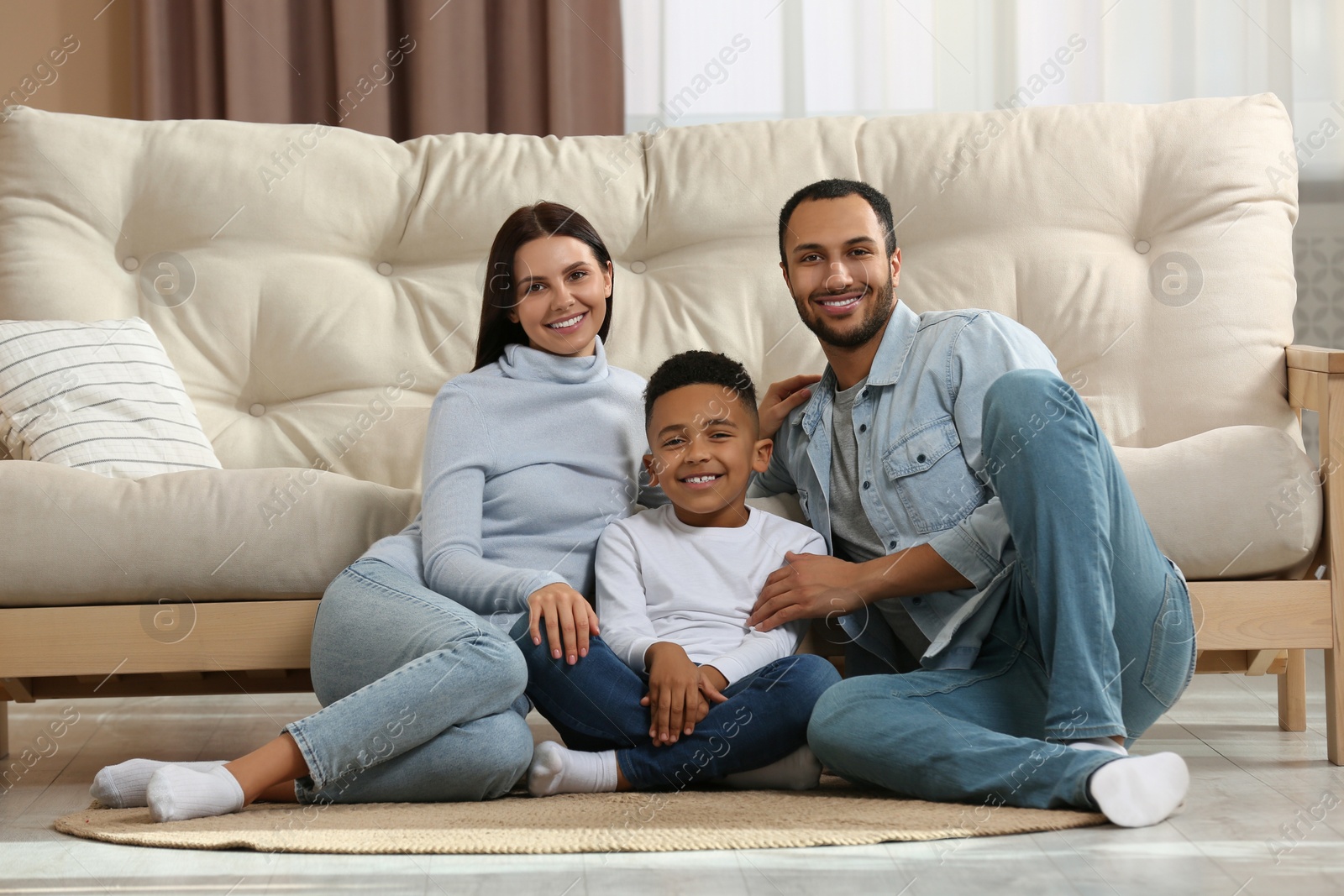 Photo of Happy international family sitting on floor at home