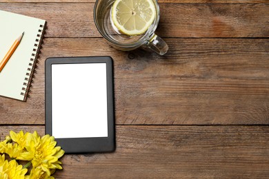 Photo of Flat lay composition with modern e-book reader on wooden table. Space for text