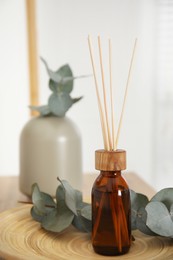 Photo of Reed diffuser and home decor on wooden tray indoors