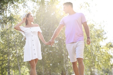 Lovely couple walking together in park on sunny day