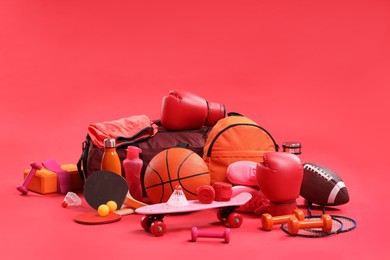 Many different sports equipment on red background