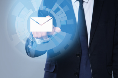 Electronic mail. Businessman pointing at virtual image of envelope, closeup