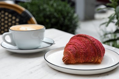 Delicious croissant and coffee on white marble table