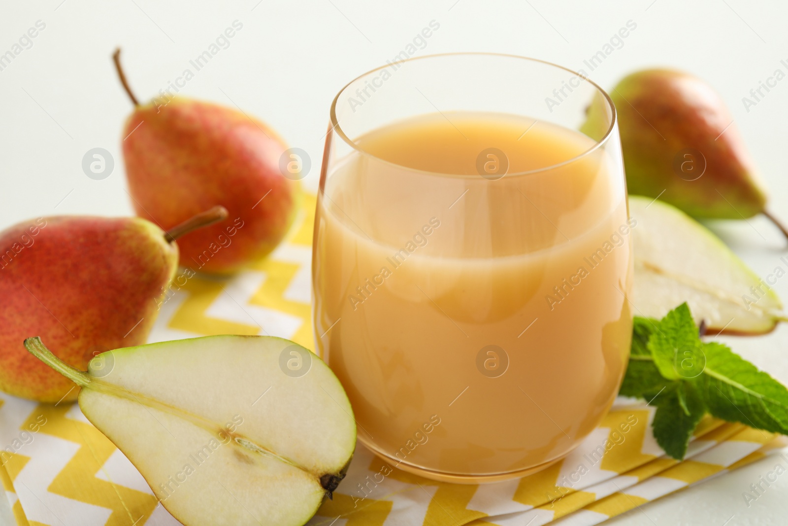 Photo of Tasty pear juice and fruits on table, closeup