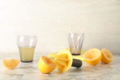 Photo of Fresh lemon half with juicer on table. Refreshing drink recipe