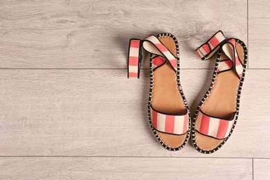 Photo of Pair of female shoes on wooden background, top view