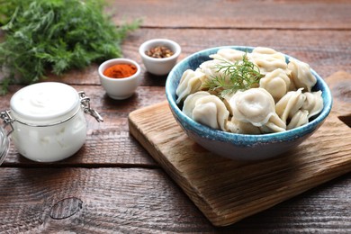 Delicious dumplings with dill on wooden table