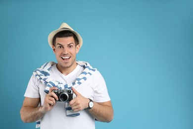 Photo of Male tourist with camera on turquoise background, space for text