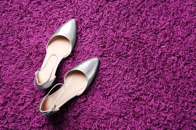 Pair of female shoes on carpet, top view