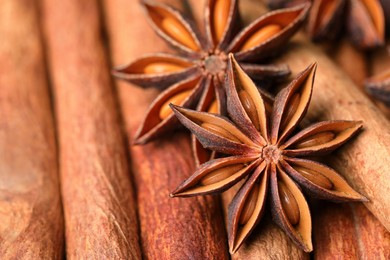 Photo of Aromatic anise stars on cinnamon sticks as background, closeup