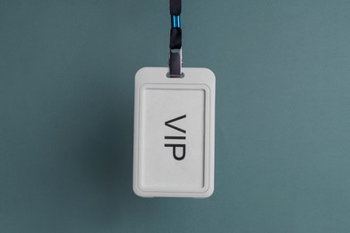 White plastic vip badge hanging on color background