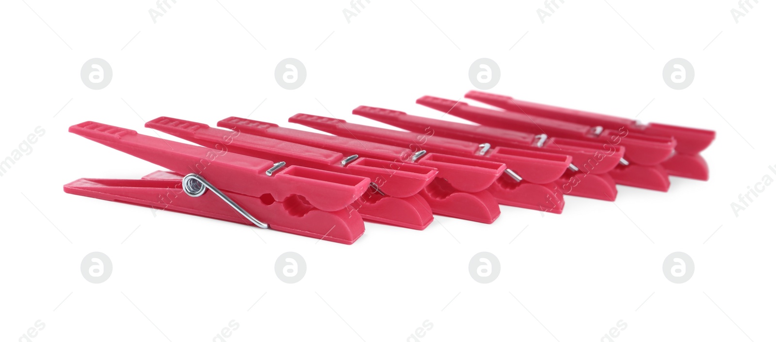 Photo of Bright pink plastic clothespins on white background