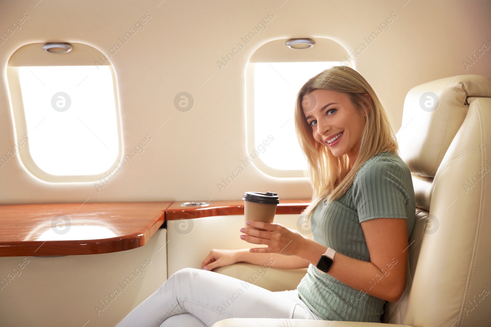 Image of Beautiful woman with paper cup on plane. Air travel