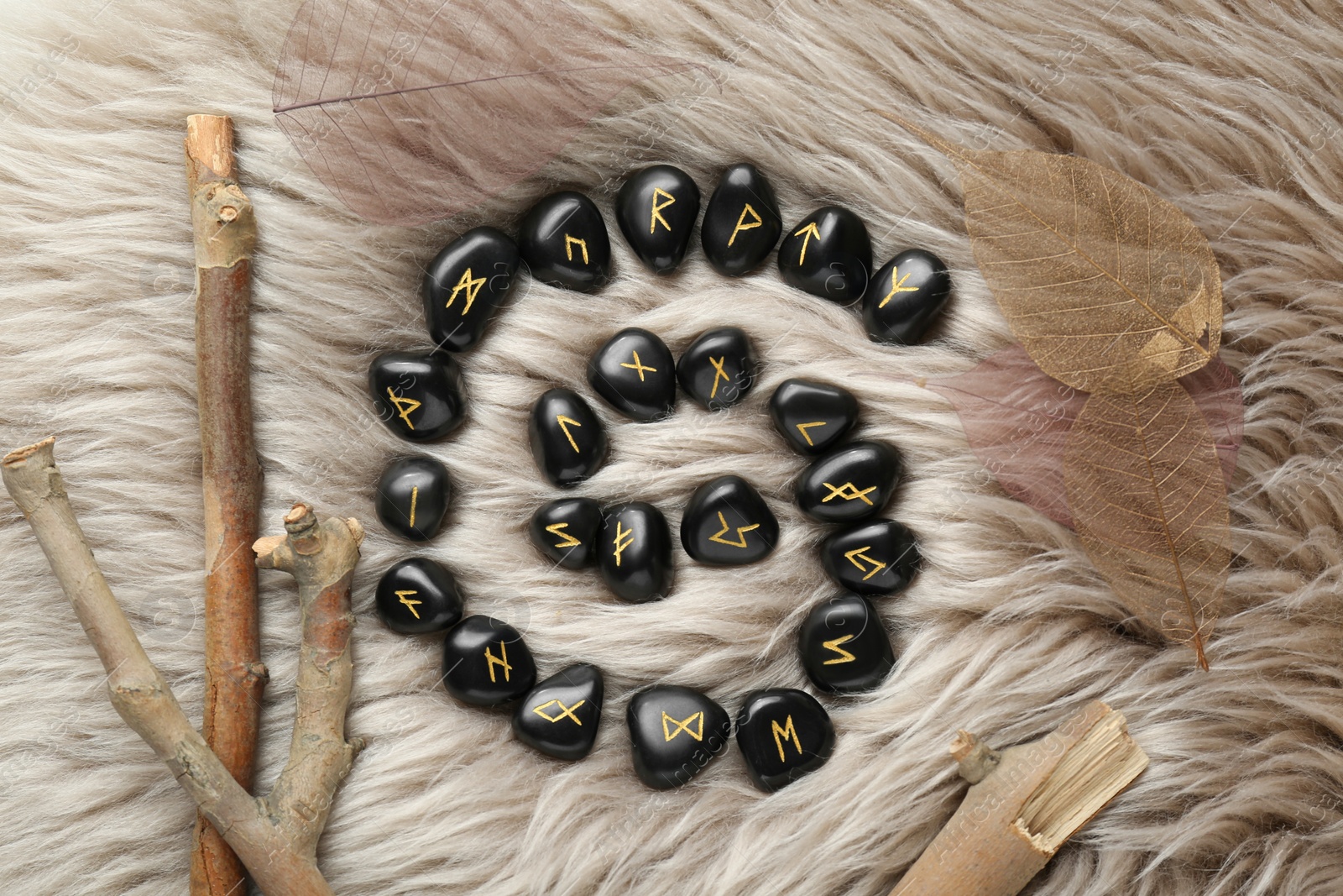 Photo of Flat lay composition with black rune stones on light faux fur