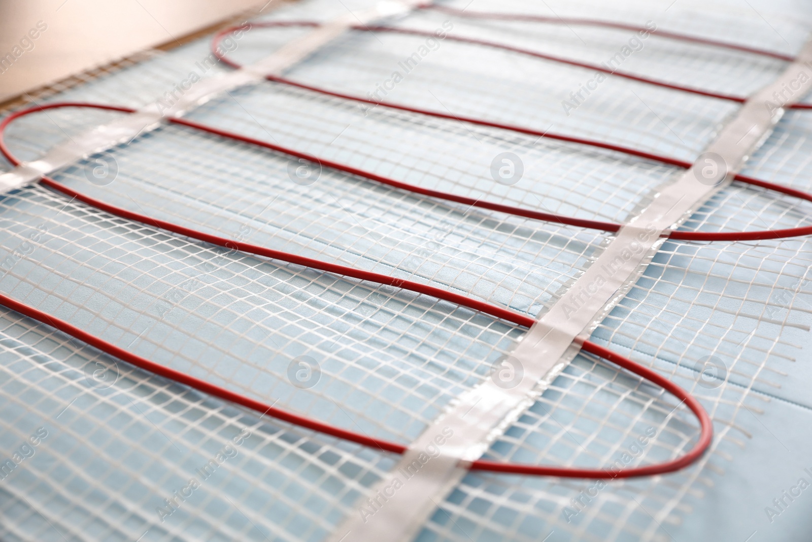 Photo of Installation of modern underfloor trace heating system indoors, closeup