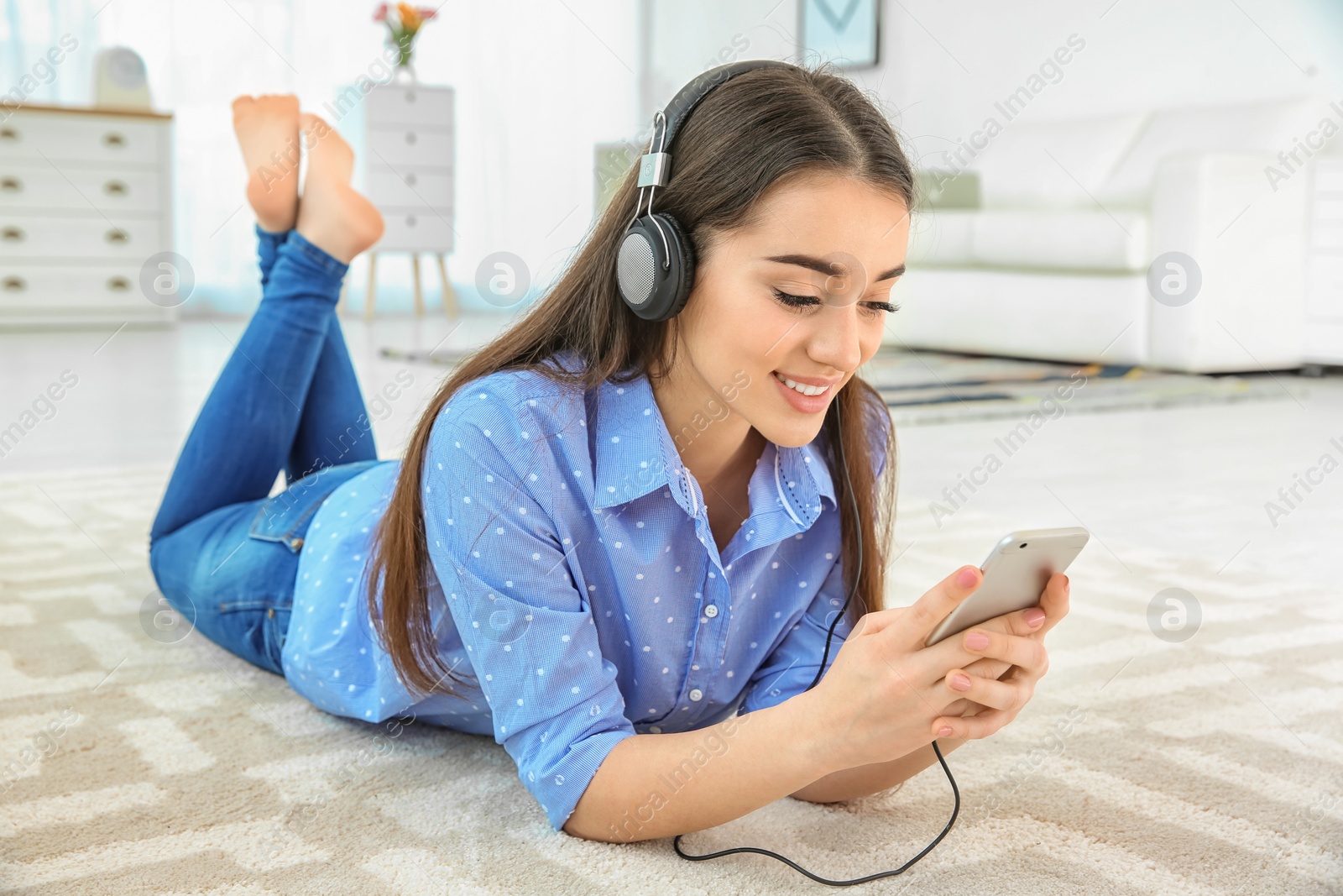 Photo of Beautiful young woman listening to music on mobile phone