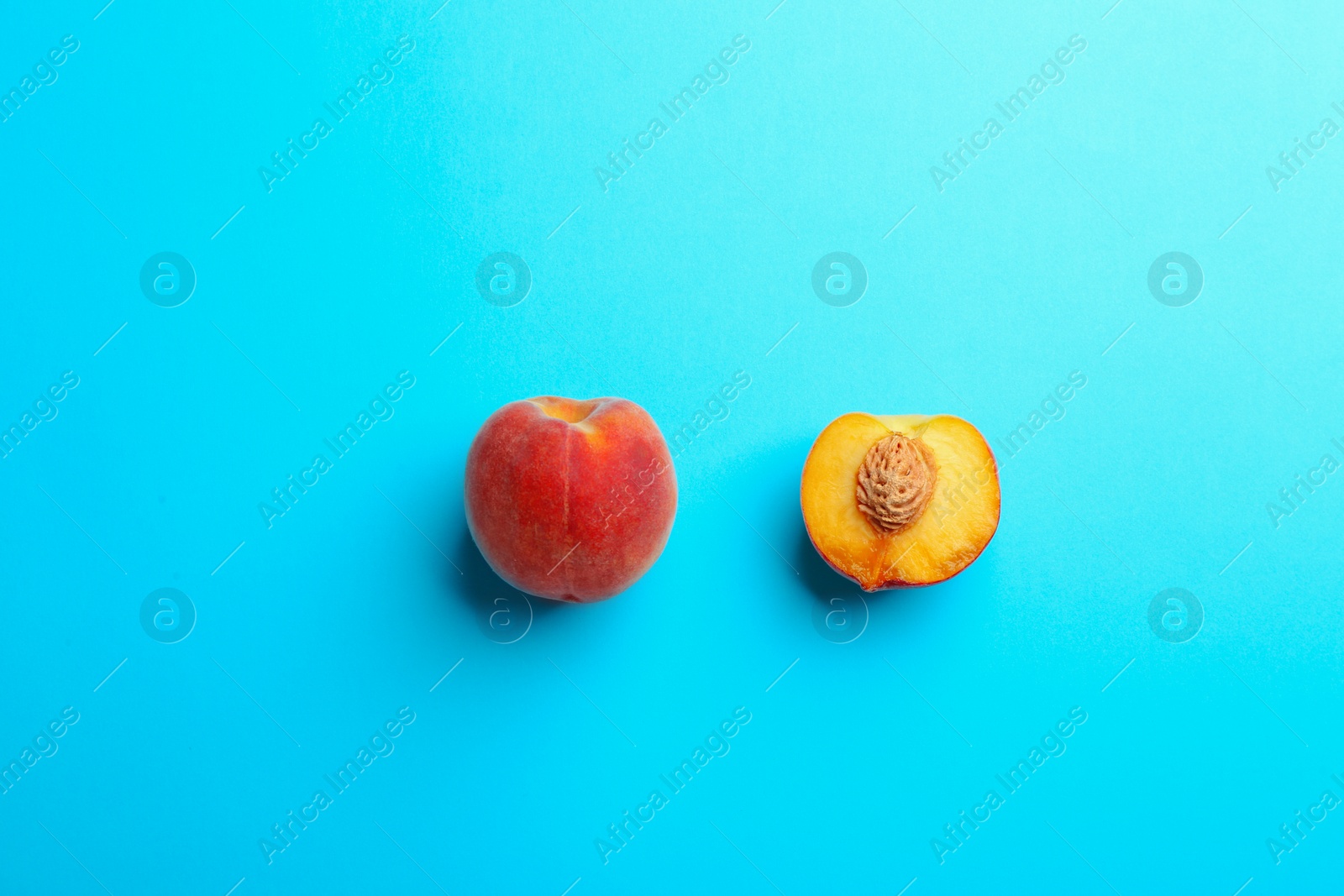 Photo of Flat lay composition with fresh peaches on blue background